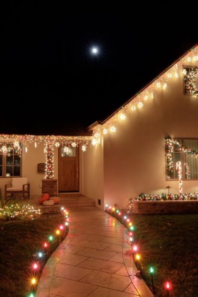 Christmas lights decorating house at night with full moon Christmas lights decorating house at night with full moon